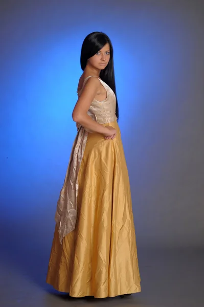 Модель в золотом платье — стоковое фото