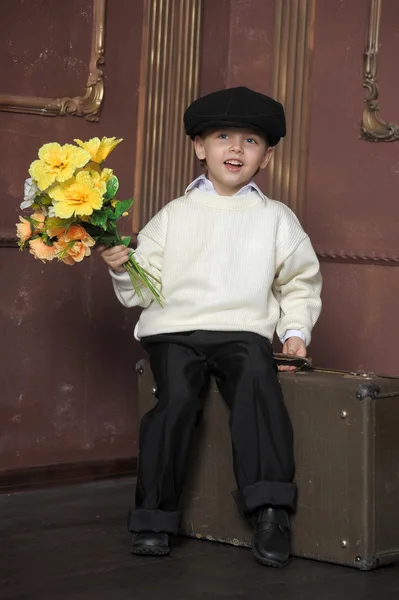 Μικρό αγόρι, φορώντας ένα καπάκι με λουλούδια στα χέρια τους — Φωτογραφία Αρχείου