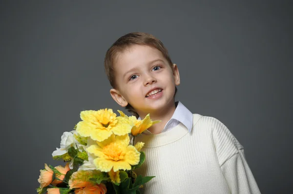 Niño pequeño con una gorra con flores en las manos — Foto de Stock