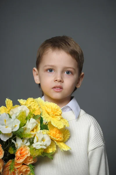 Niño pequeño con una gorra con flores en las manos —  Fotos de Stock