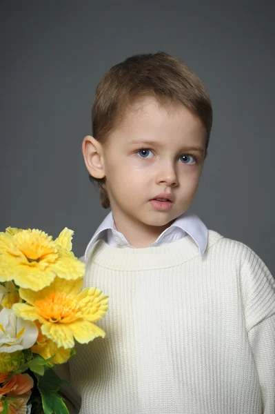 Kleine jongen een cap met bloemen dragen in hun handen — Stockfoto