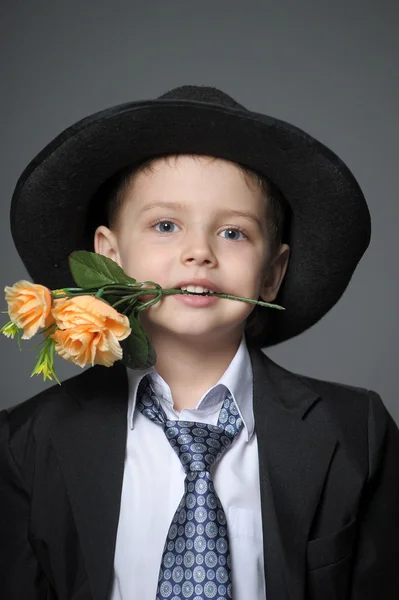 그들의 손에 있는 꽃을 가진 모자를 쓰고 어린 소년 — 스톡 사진