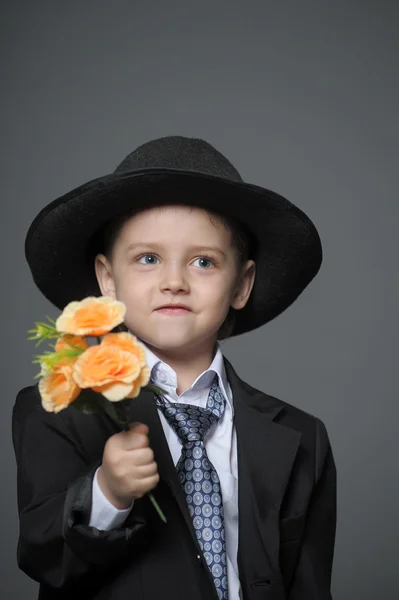 Niño pequeño con una gorra con flores en las manos —  Fotos de Stock