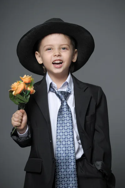 Küçük çocuk ellerinde çiçeklerle şapkası — Stok fotoğraf
