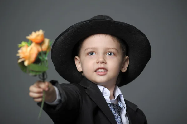 그들의 손에 있는 꽃을 가진 모자를 쓰고 어린 소년 — 스톡 사진