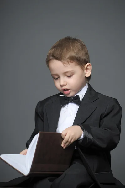 Boy in a suit with a book — Stock Photo, Image
