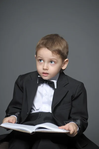 Boy in a suit with a book — Stock Photo, Image