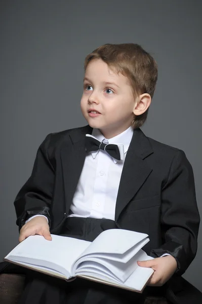 Мальчик в костюме с книгой — стоковое фото
