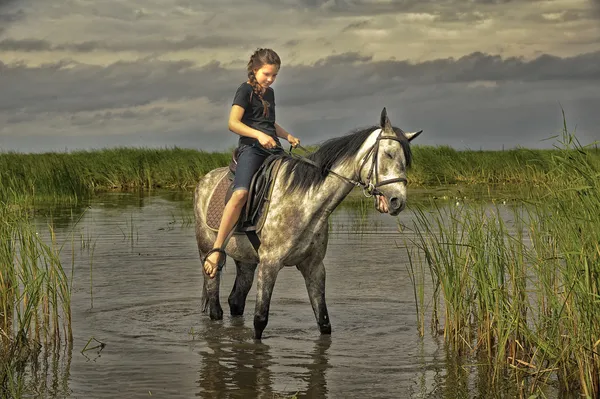 十几岁的女孩在水中的一匹马 — 图库照片
