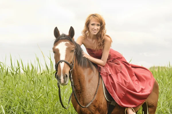 Mujer vestida de rojo en un caballo — Foto de Stock