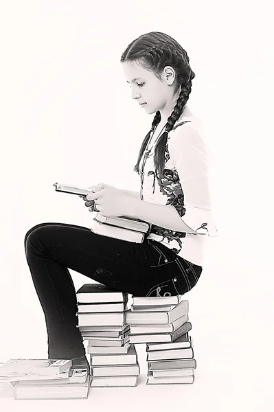 Schattige jonge vrouw met een stapel boeken — Stockfoto