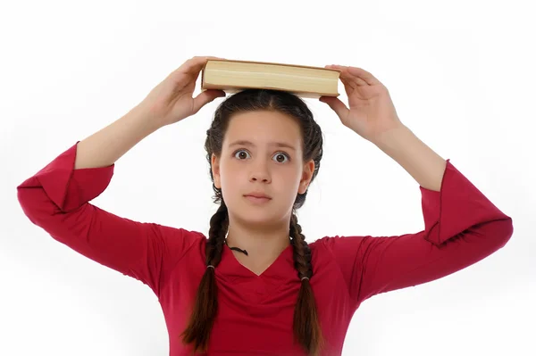 Menina com seus livros em sua cabeça — Fotografia de Stock