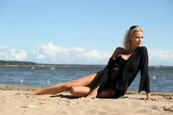 Sexy blonde in black on the beach — Stock Photo, Image