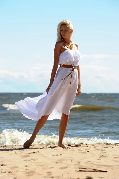 Mädchen im weißen Kleid am Strand — Stockfoto