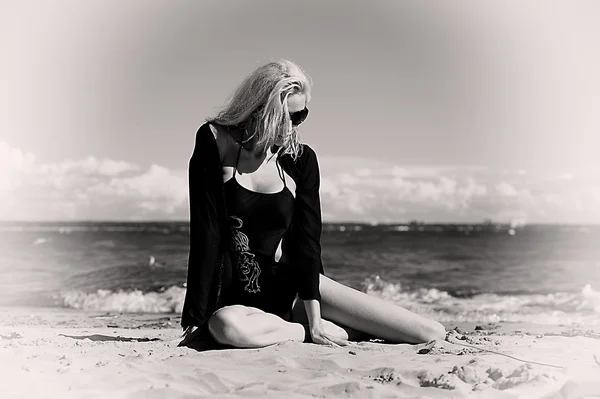 Sexig blondin i svart på stranden — Stockfoto