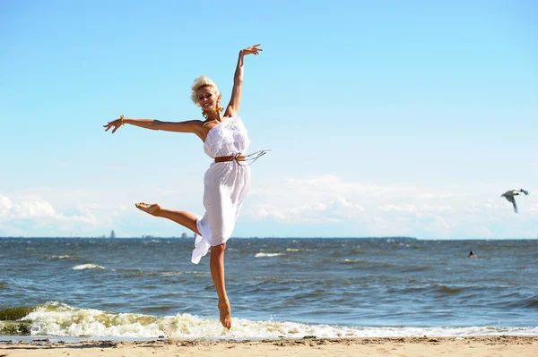 Mädchen im weißen Kleid am Strand — Stockfoto