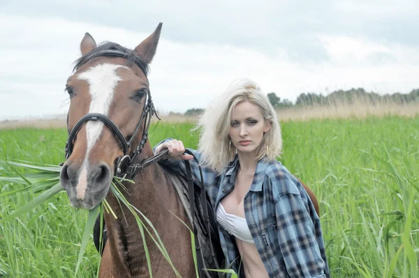 Seksowna blondynka obok konia — Zdjęcie stockowe