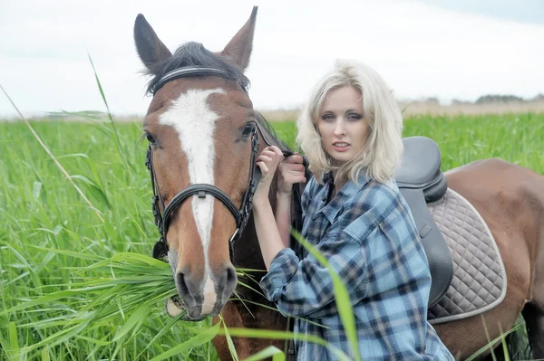 Сексуальная блондинка возле лошади — стоковое фото