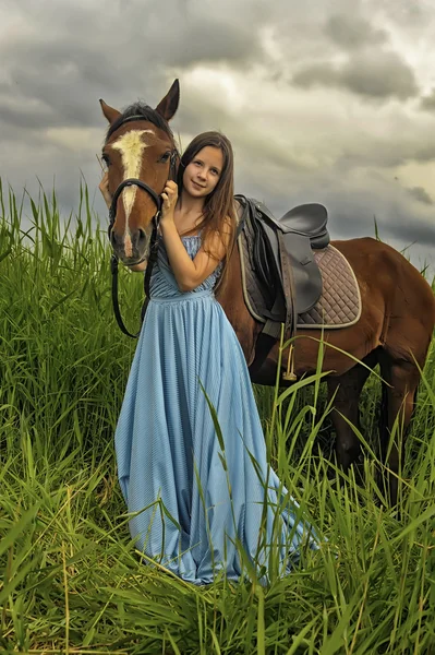 Fille en robe longue avec un cheval — Photo