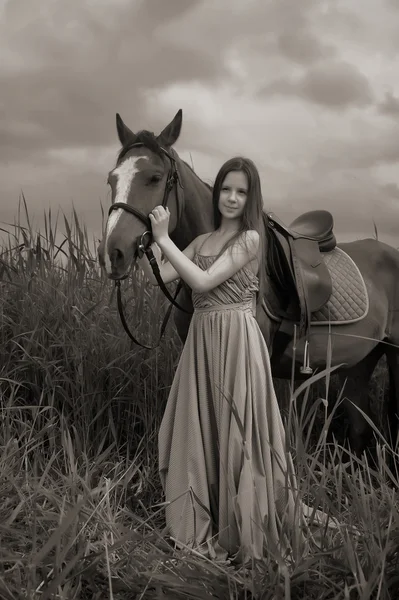 Dívka v dlouhé šaty s koněm — Stock fotografie