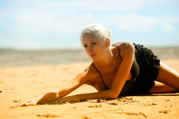 Sexy Blondine in schwarz am Strand — Stockfoto