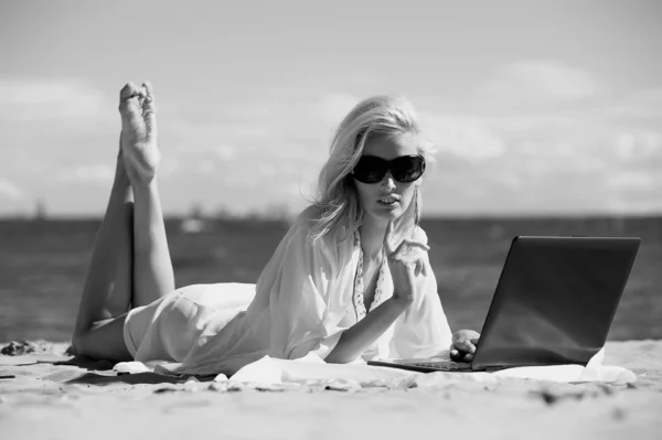 快乐的金发女人在用一台笔记本电脑的海滩 — 图库照片
