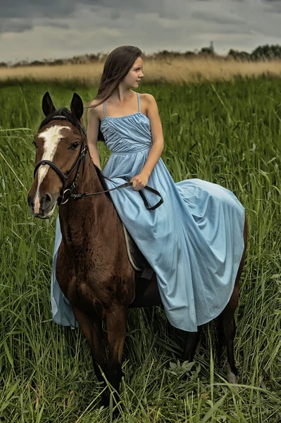 Bir atı ile mavi elbiseli kız — Stok fotoğraf