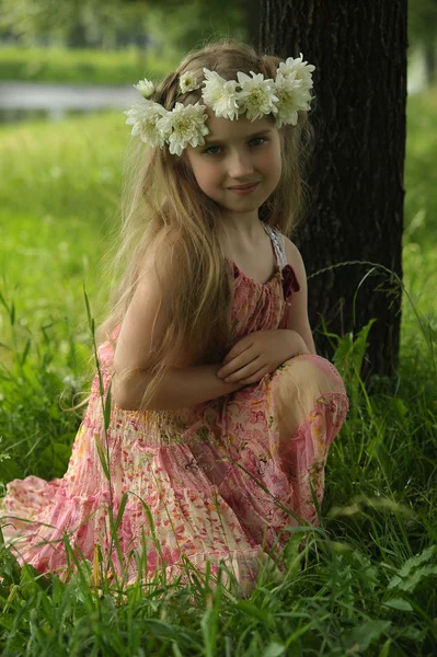 Liten flicka i en krans av vita blommor — Stockfoto