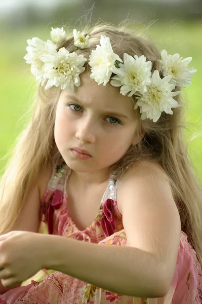 Kleines Mädchen in einem Kranz aus weißen Blumen — Stockfoto