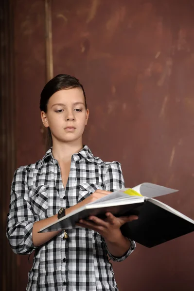 Adolescente chica hojeando un libro — Foto de Stock