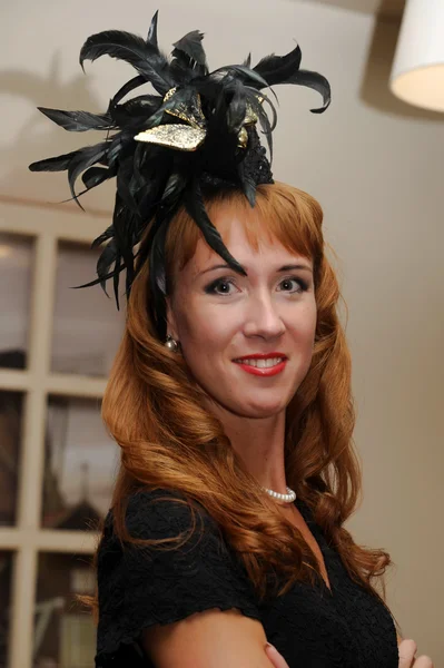 Женщина в маленькой черной шляпе с перьями — стоковое фото