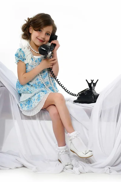Liten flicka med en retro telefon — Stockfoto