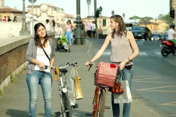 Две девушки совершают покупки в Пизе на велосипеде — стоковое фото