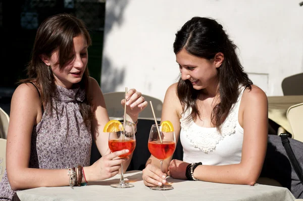 Две молодые девушки, пока они пьют коктейль — стоковое фото