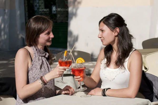 Две молодые девушки, пока они пьют коктейль — стоковое фото