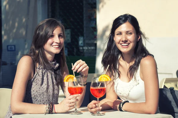 Deux jeunes filles pendant qu'elles prennent un cocktail Images De Stock Libres De Droits
