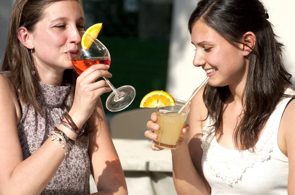 Två unga flickor medan de tar en kall drink Stockfoto