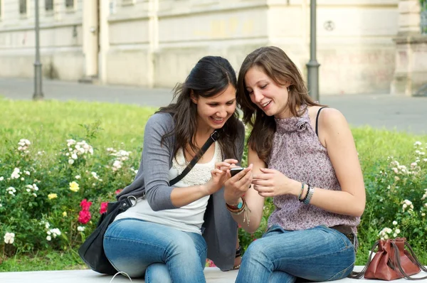 Twee meisje terwijl ze maken een spreken een telefoon — Stockfoto