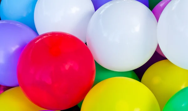 stock image A red balloon between other colorful balloons