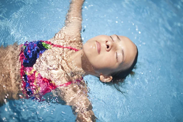 Girl in the swimming pool in the very sunny day — Stock Photo, Image