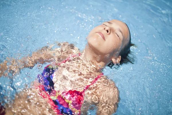 Menina na piscina no dia muito ensolarado — Fotografia de Stock