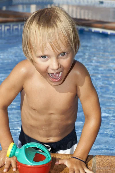 スイミング プールで水やりを持つ少年ことができます。 — ストック写真