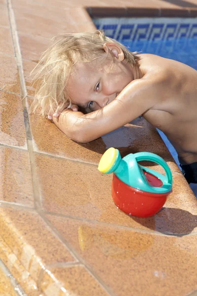 Ragazzo con annaffiatoio in piscina — Foto Stock