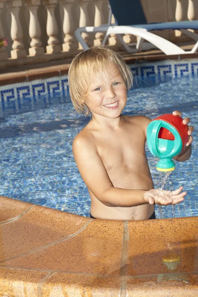 スイミング プールで水やりを持つ少年ことができます。 — ストック写真