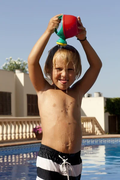 Menino com regador na piscina — Fotografia de Stock