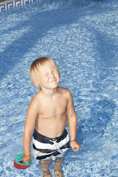 Garçon avec arrosoir dans la piscine Image En Vente