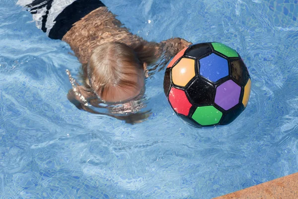 Хлопчик з кольоровим м'ячем у басейні — стокове фото