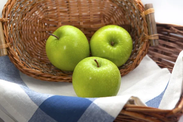 Tre mele verdi nel cesto di vimini marrone — Foto Stock