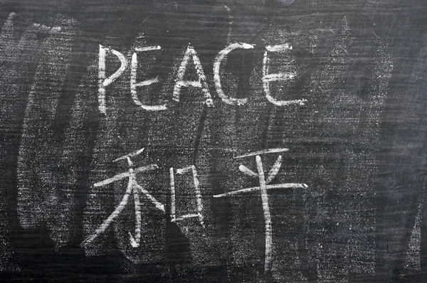 Peace - word written on a blackboard with a Chinese translation — Stock Photo, Image