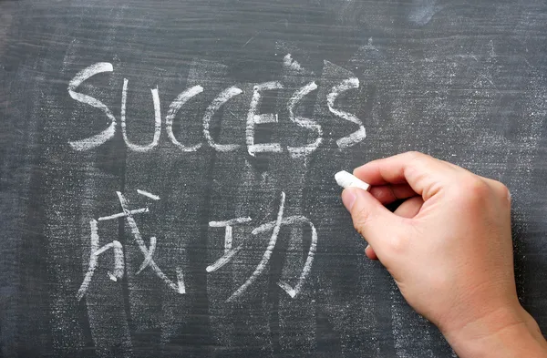 Success - слово, написанное на доске с китайским переводом — стоковое фото